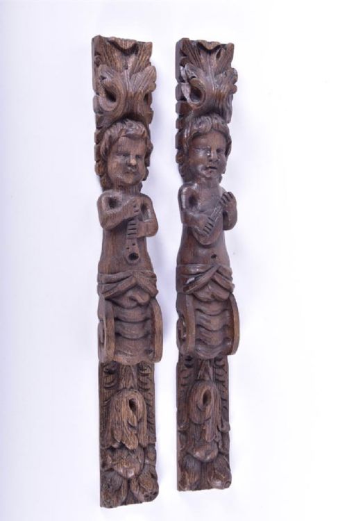 pair of carved oak wall hangings showing musicians