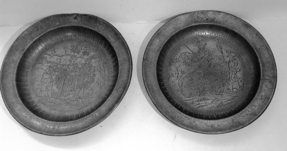 a pair of pewter engraved plates