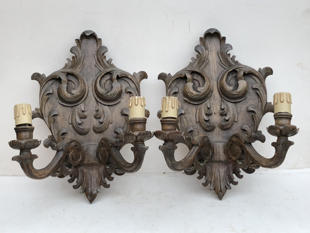 a pair of carved walnut wall lights
