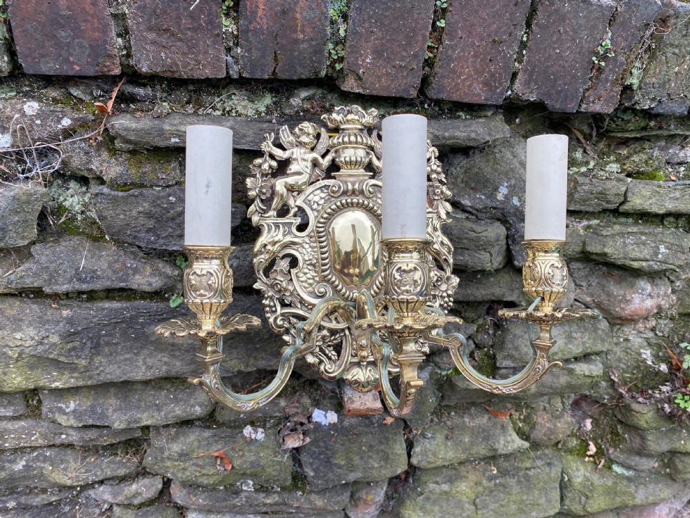a three armed brass wall light