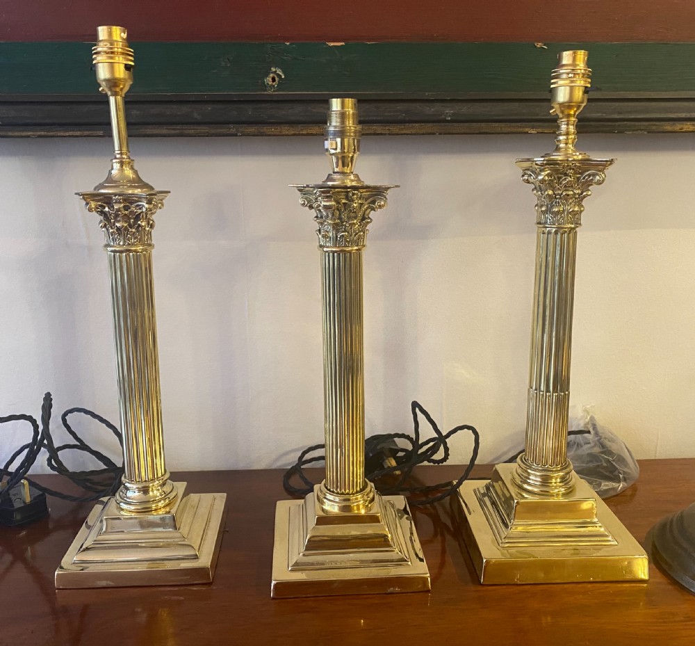 three edwardian brass corinthian column lamps