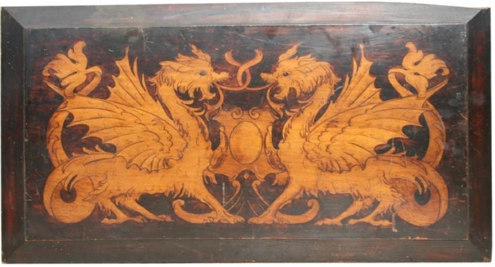 a wooden panel decorated with a pair of griffins